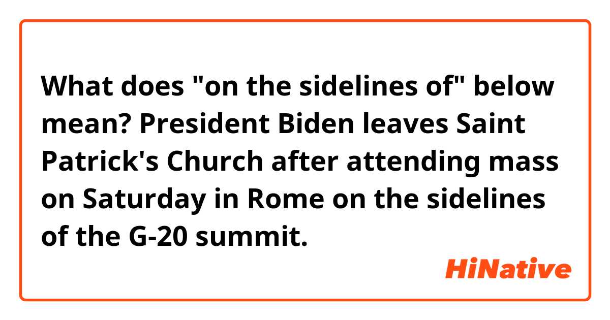 What does "on the sidelines of" below mean?

President Biden leaves Saint Patrick's Church after attending mass on Saturday in Rome on the sidelines of the G-20 summit.